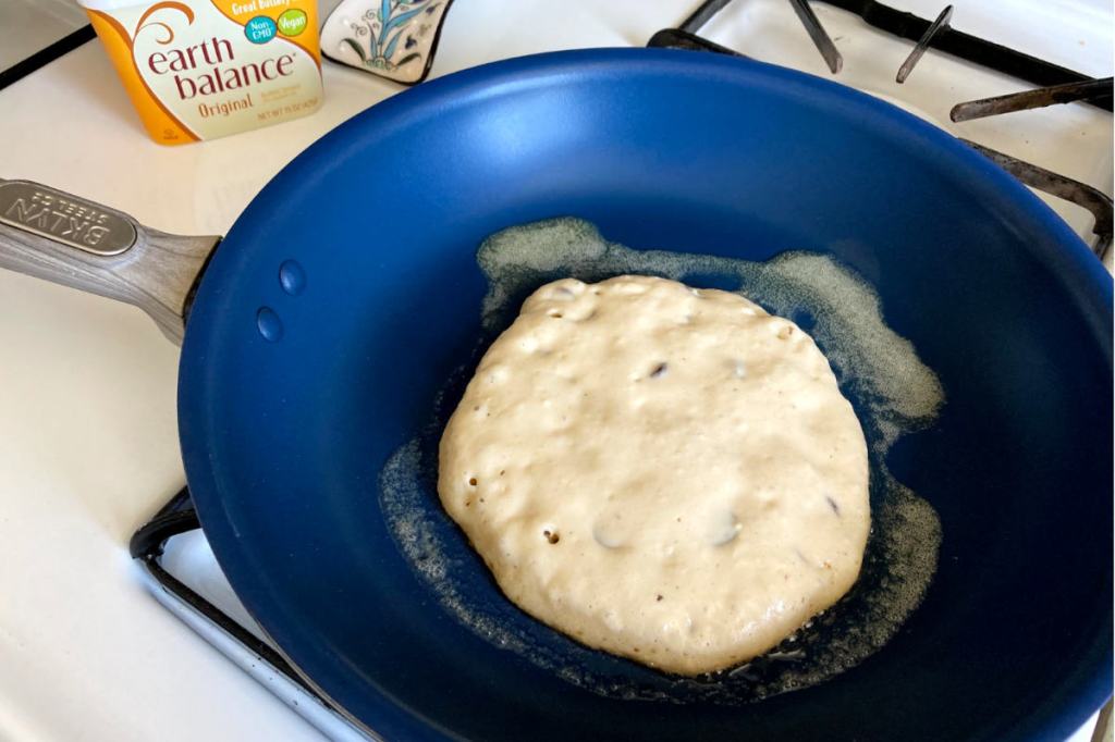 Blue pan with one vegan chocolate chip pancake with earth balance butter